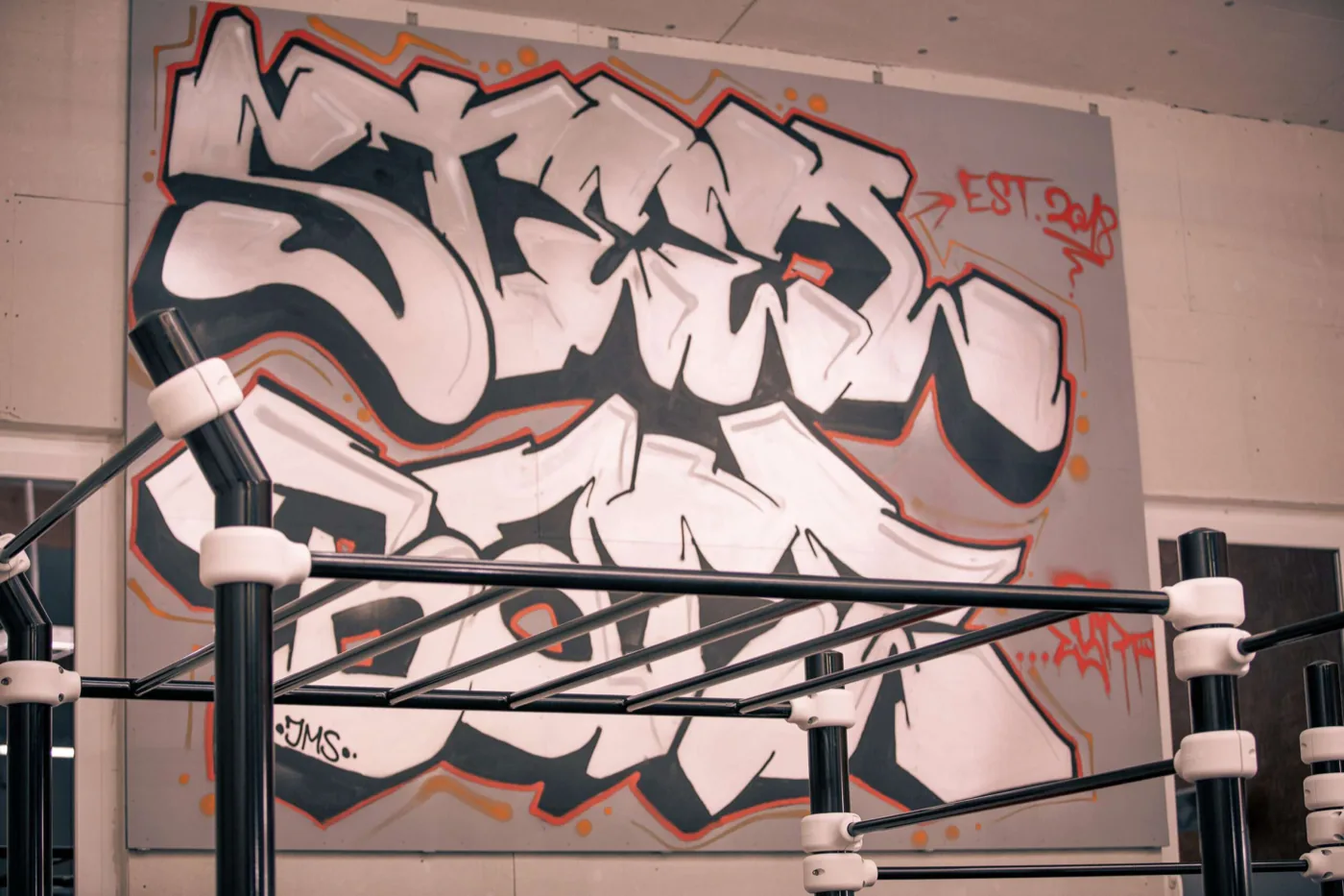 Stangen vor der Graffiti-Wand